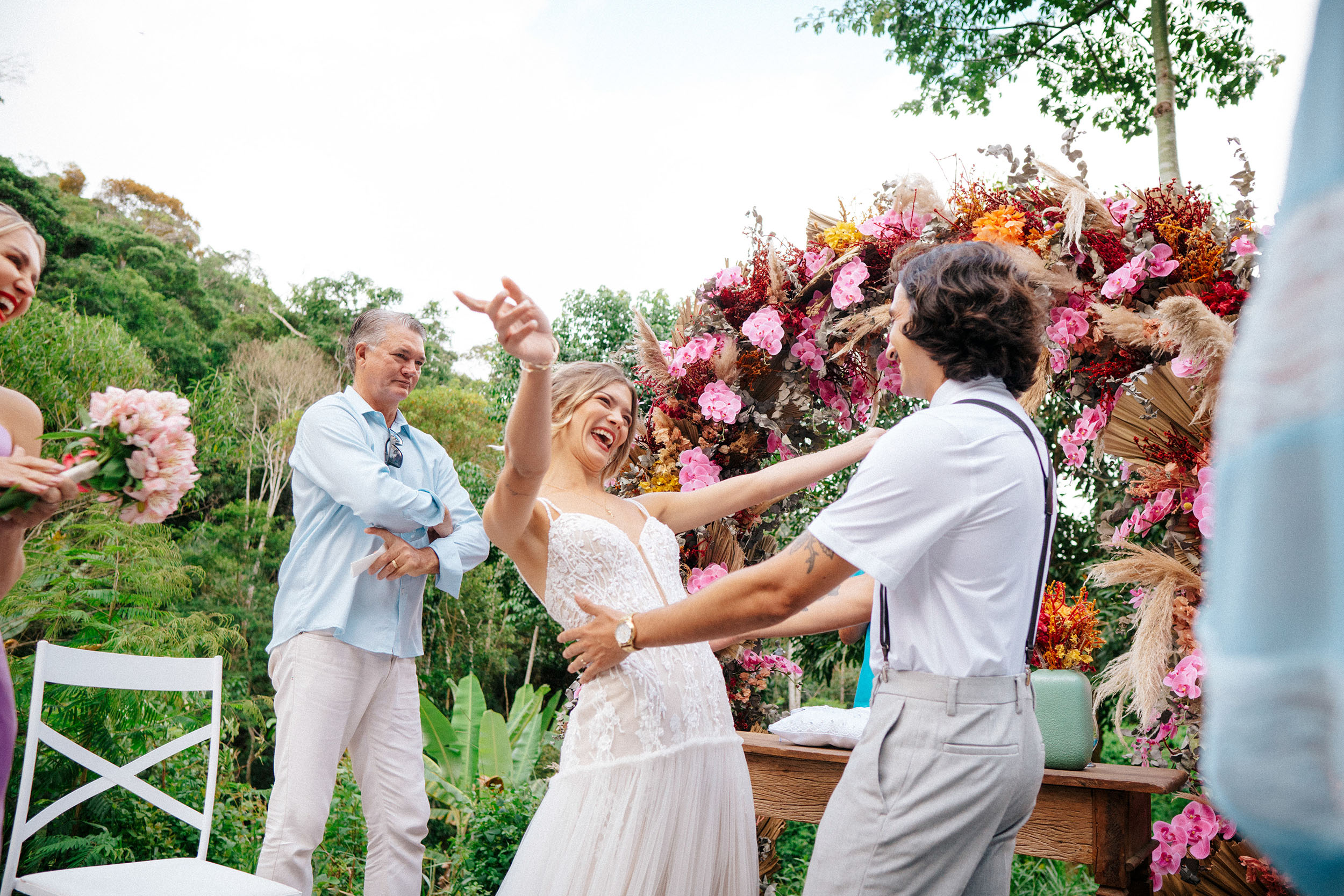 Casal dançando embaixo de decoração com flores no casamento